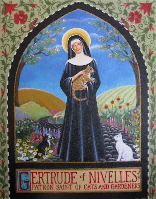 A painting of St. Gertrude of Nivelles, Patron Saint of cats and gardeners. She is standing in a beautiful, flowering meadow, holding and petting a cat as two other cats look on.